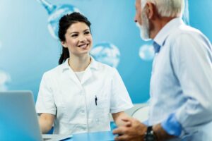 Friendly dental professional speaking with an elderly patient