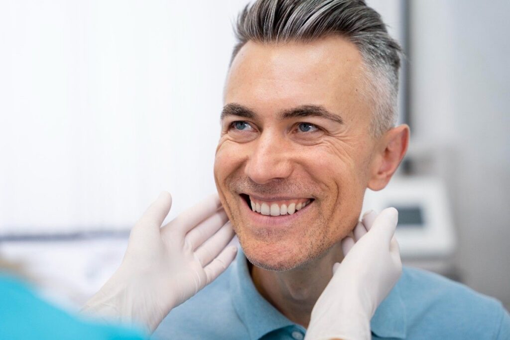 Dentist examining smiling patient’s teeth close-up