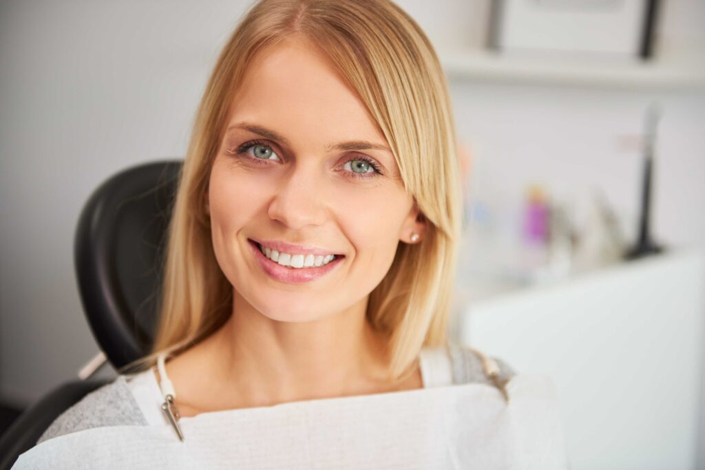 Woman smiling warmly with bright, healthy-looking teeth.