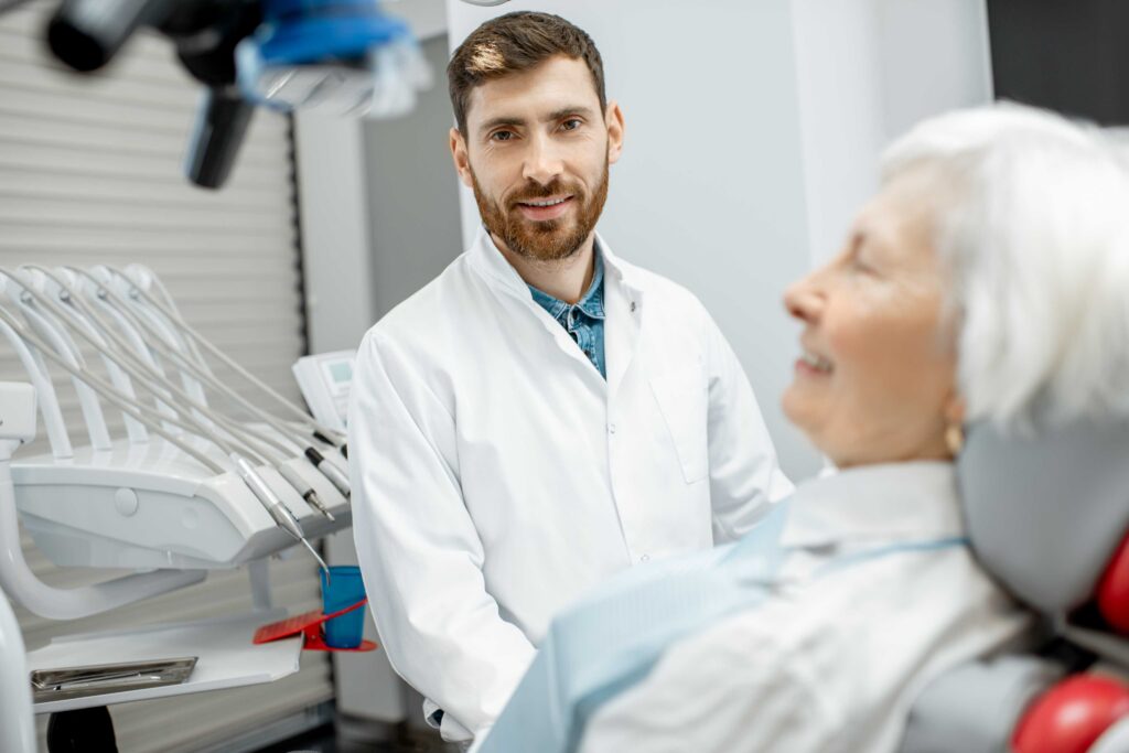 Patient seated in a dental chair with a dentist nearby.