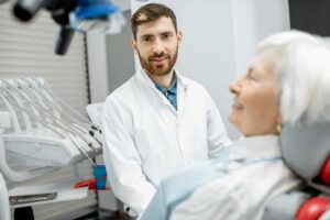 Patient seated in a dental chair with a dentist nearby.